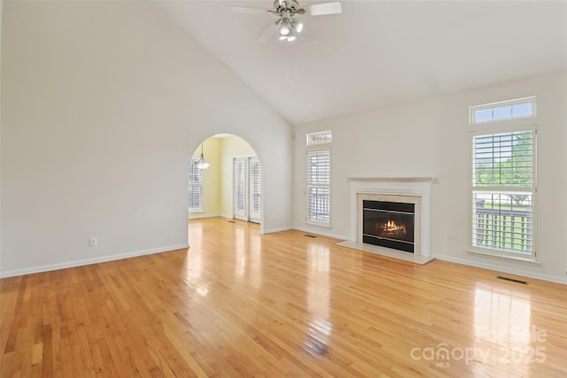 2321 Oberwood Dr, Charlotte, NC 28270 - unfurnished living room featuring light wood-style floors, high vaulted ceiling, healthy amount of natural light, a ceiling fan, and a high end fireplace