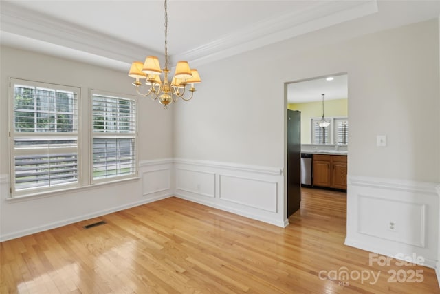 2321 Oberwood Dr, Charlotte, NC 28270 - unfurnished room with a chandelier, light wood-style floors, wainscoting, ornamental molding, and a decorative wall