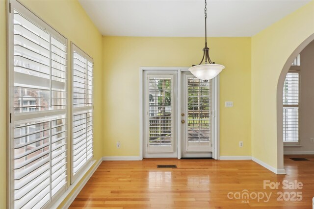 2321 Oberwood Dr, Charlotte, NC 28270 - unfurnished dining area with arched walkways and light wood-style floors