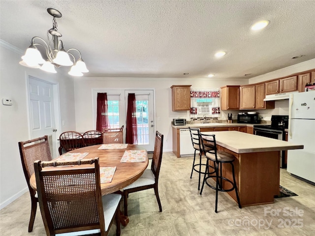 1031 Daniel Dr, Stanley, NC 28164 - kitchen featuring white appliances, ornamental molding, under cabinet range hood, a kitchen island, and a chandelier