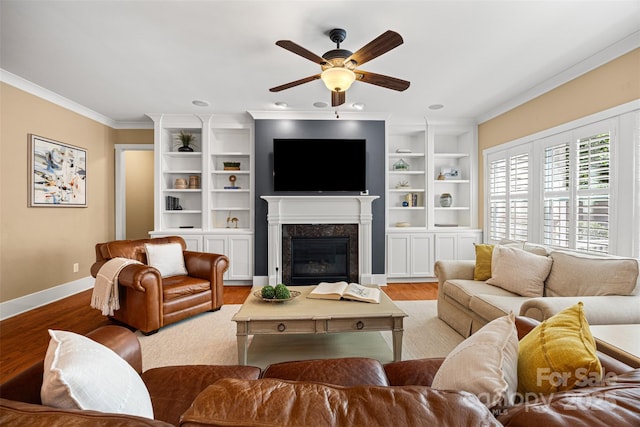 6422 Northern Red Oak Dr, Mint Hill, NC 28227 - living room featuring ornamental molding, ceiling fan, wood finished floors, a fireplace, and built in shelves