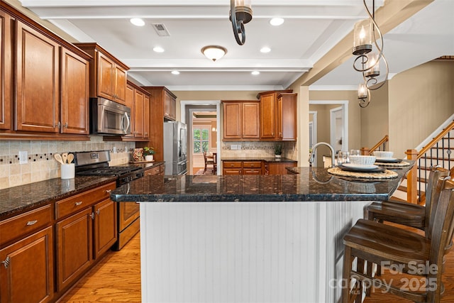 6422 Northern Red Oak Dr, Mint Hill, NC 28227 - kitchen featuring appliances with stainless steel finishes, ornamental molding, a kitchen bar, light wood finished floors, and backsplash