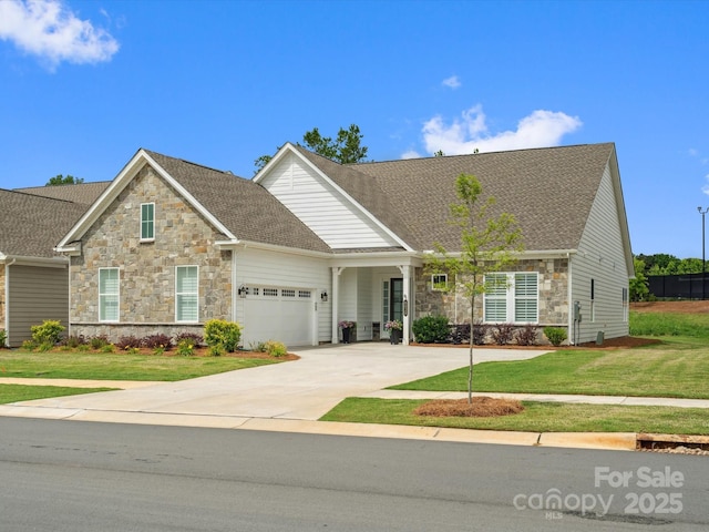 6020 Waldorf Ave, Monroe, NC 28110 - view of front of home with stone siding, an attached garage, a front yard, driveway, and a shingled roof