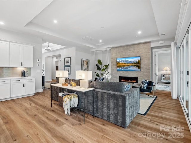 6020 Waldorf Ave, Monroe, NC 28110 - living room with a fireplace, light wood-style floors, recessed lighting, a chandelier, and a raised ceiling
