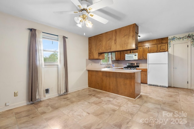 4214 Horseshoe Bend Rd, Hudson, NC 28638 - kitchen with white appliances, brown cabinetry, a peninsula, and healthy amount of natural light