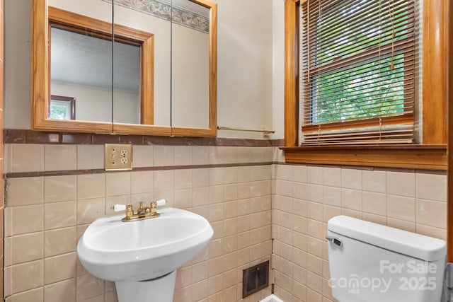 4214 Horseshoe Bend Rd, Hudson, NC 28638 - bathroom featuring tile walls, healthy amount of natural light, toilet, a sink, and wainscoting