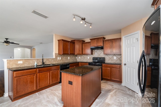 12829 Brandenburg Ln, Midland, NC 28107 - kitchen with a sink, black appliances, brown cabinetry, and a peninsula