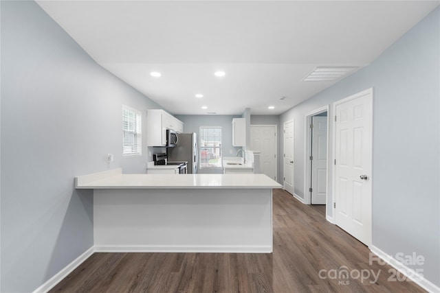 2045 Pin Oak Pl, Cramerton, NC 28032 - kitchen featuring appliances with stainless steel finishes, white cabinets, dark wood finished floors, light countertops, and a peninsula