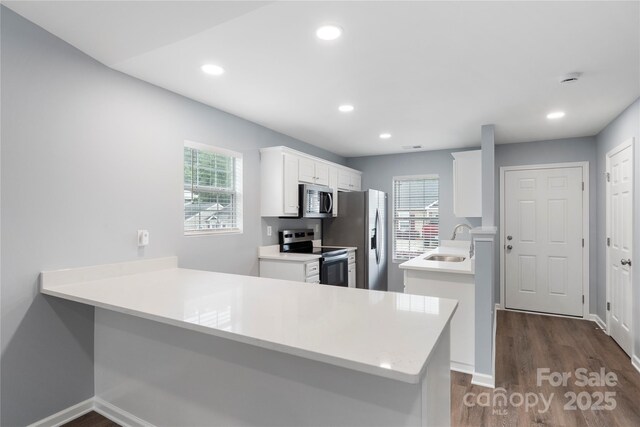 2045 Pin Oak Pl, Cramerton, NC 28032 - kitchen featuring stainless steel appliances, a peninsula, dark wood-style floors, white cabinetry, and light countertops