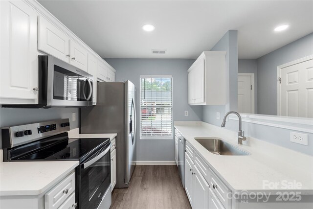 2045 Pin Oak Pl, Cramerton, NC 28032 - kitchen featuring appliances with stainless steel finishes, wood finished floors, white cabinets, light countertops, and recessed lighting