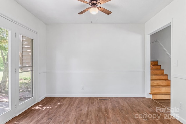 4980 Murray Rd, Winston Salem, NC 27106 - unfurnished room featuring healthy amount of natural light, stairs, wood finished floors, and ceiling fan