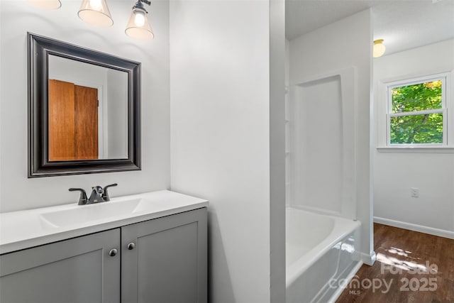 4980 Murray Rd, Winston Salem, NC 27106 - bathroom featuring vanity, wood finished floors, baseboards, and bathing tub / shower combination
