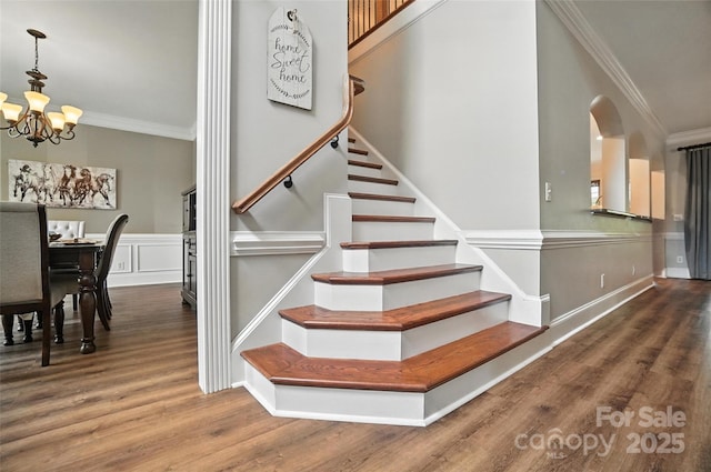 5916 Four Wood Dr, Matthews, NC 28104 - stairway featuring a chandelier, crown molding, wood finished floors, and arched walkways
