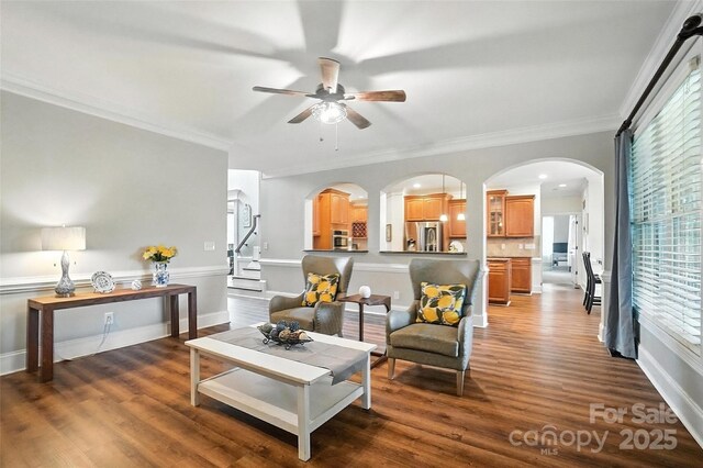 5916 Four Wood Dr, Matthews, NC 28104 - living room featuring arched walkways, a ceiling fan, wood finished floors, and ornamental molding