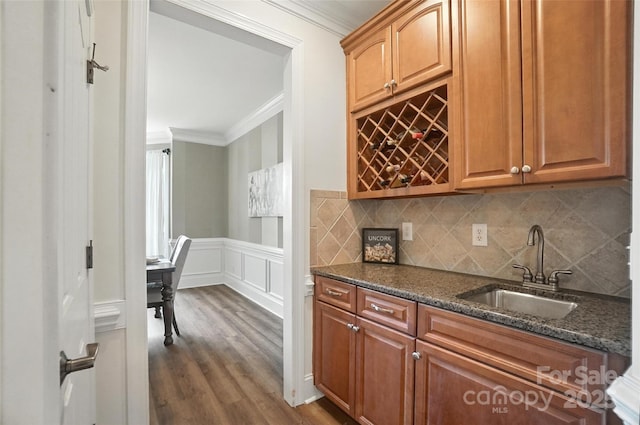 5916 Four Wood Dr, Matthews, NC 28104 - kitchen with ornamental molding, dark stone countertops, dark wood finished floors, a decorative wall, and wainscoting