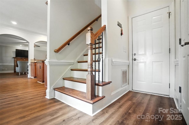 5916 Four Wood Dr, Matthews, NC 28104 - foyer featuring arched walkways, wood finished floors, stairway, and recessed lighting