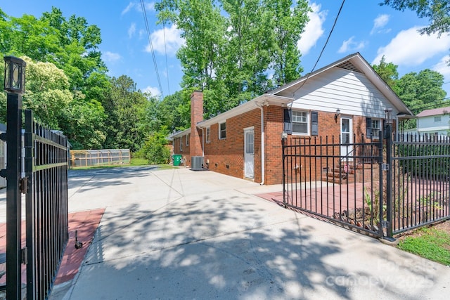 5720 Amity Pl, Charlotte, NC 28212 - view of property exterior with brick siding, concrete driveway, a chimney, and a gate