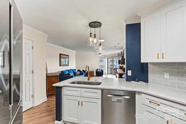 1038 SW Dr, Davidson, NC 28036 - kitchen with appliances with stainless steel finishes, open floor plan, a peninsula, ornamental molding, and light wood-style flooring