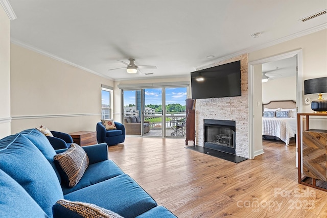 1038 SW Dr, Davidson, NC 28036 - living room with a ceiling fan, ornamental molding, light wood-type flooring, and a fireplace