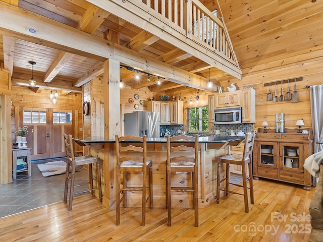 1526 Pisgah Preserve Dr Unit 7-8, Nebo, NC 28761 - kitchen with stainless steel appliances, dark countertops, a wooden ceiling with exposed beams, wooden walls, and decorative backsplash