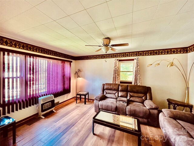135 Smathers St, Clyde, NC 28721 - living room with heating unit, hardwood / wood-style flooring, ceiling fan, and baseboards
