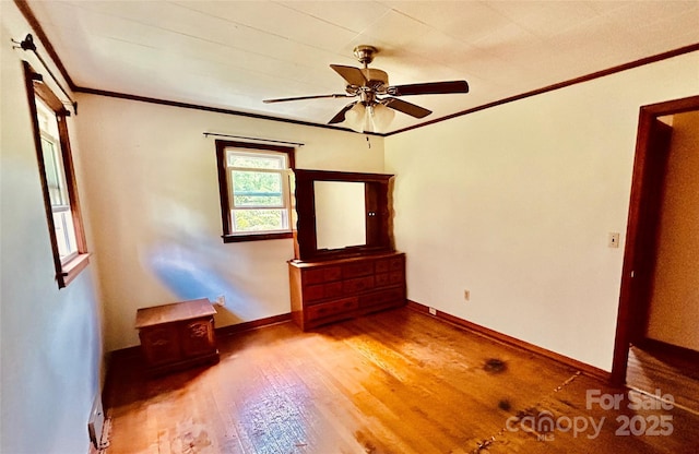 135 Smathers St, Clyde, NC 28721 - empty room with crown molding, a wood stove, wood finished floors, ceiling fan, and baseboards