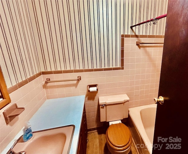 135 Smathers St, Clyde, NC 28721 - bathroom featuring a tub to relax in, toilet, tile walls, and a sink