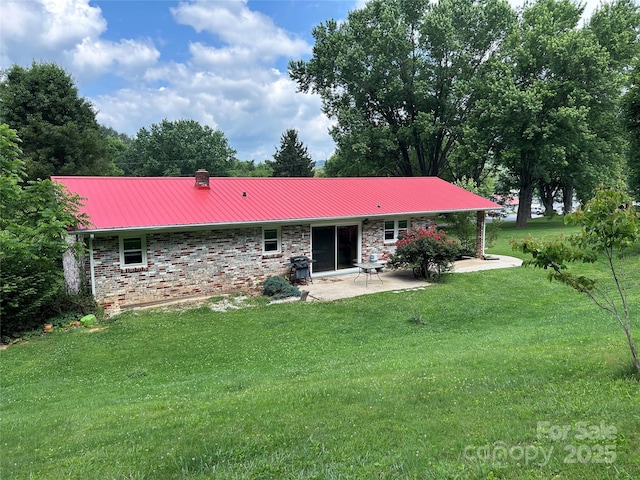 135 Smathers St, Clyde, NC 28721 - rear view of house with a patio area, a lawn, metal roof, a chimney, and brick siding