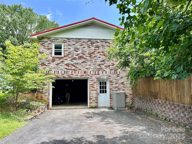 135 Smathers St, Clyde, NC 28721 - view of property exterior featuring driveway, brick siding, central AC, and a garage