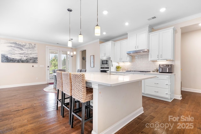 16324 Loch Raven Rd, Huntersville, NC 28078 - kitchen featuring appliances with stainless steel finishes, ornamental molding, tasteful backsplash, a center island with sink, and white cabinetry