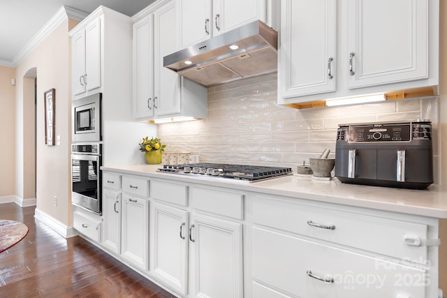 16324 Loch Raven Rd, Huntersville, NC 28078 - kitchen featuring appliances with stainless steel finishes, under cabinet range hood, ornamental molding, arched walkways, and tasteful backsplash