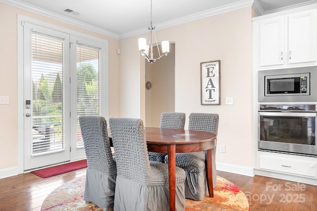 16324 Loch Raven Rd, Huntersville, NC 28078 - dining room featuring wood finished floors, a chandelier, and crown molding