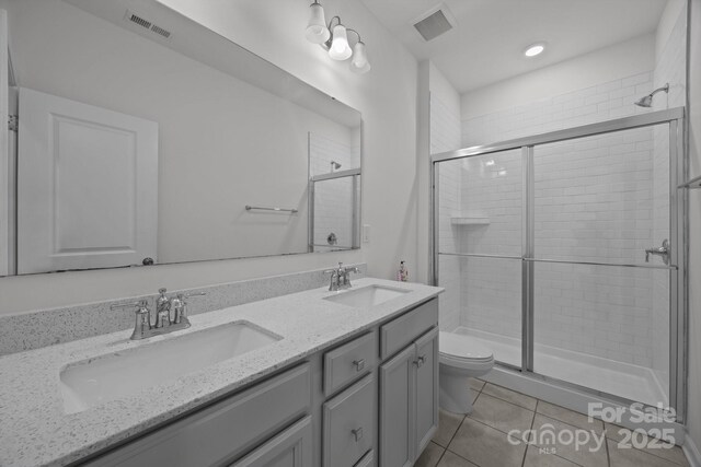 4427 Poplin Grove Dr, Indian Trail, NC 28079 - bathroom featuring toilet, a stall shower, double vanity, tile patterned floors, and recessed lighting