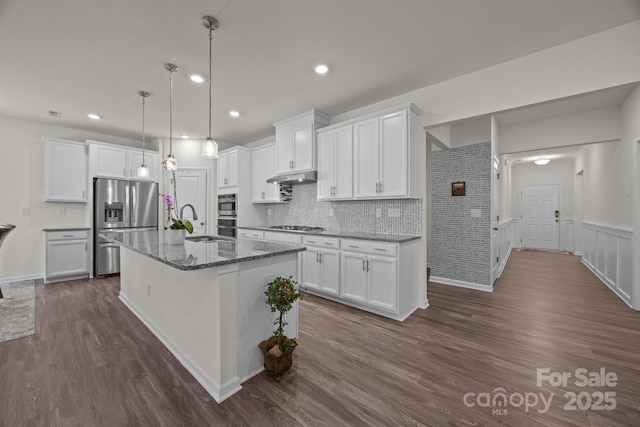 4427 Poplin Grove Dr, Indian Trail, NC 28079 - kitchen featuring appliances with stainless steel finishes, under cabinet range hood, a sink, dark wood-type flooring, and white cabinetry