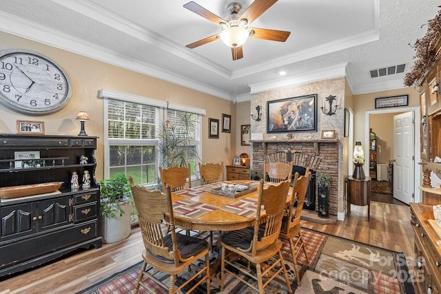 381 US-70 Hwy, Black Mountain, NC 28711 - dining area featuring a raised ceiling, wood finished floors, a fireplace, ceiling fan, and ornamental molding