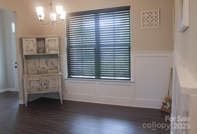 858 Oak Manor Dr SE, Concord, NC 28025 - unfurnished dining area featuring a decorative wall, a chandelier, dark wood-style floors, and wainscoting