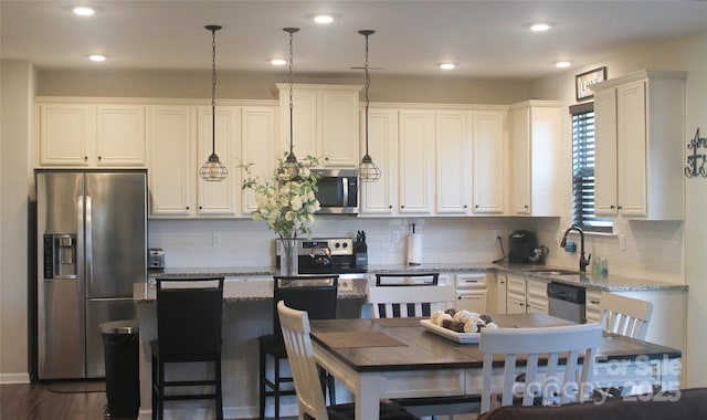 858 Oak Manor Dr SE, Concord, NC 28025 - kitchen with stainless steel appliances, light stone counters, white cabinets, and recessed lighting