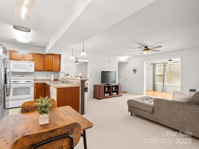 91 Morningside Ln, Hendersonville, NC 28792 - kitchen featuring white appliances, open floor plan, a peninsula, brown cabinetry, and a ceiling fan