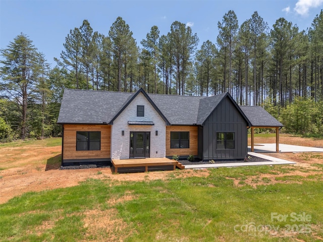 1872 Piney Mountain Church Rd, Bostic, NC 28018 - modern farmhouse style home featuring board and batten siding, a wooden deck, a front lawn, and a shingled roof