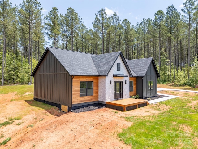 1872 Piney Mountain Church Rd, Bostic, NC 28018 - view of front facade featuring a shingled roof, board and batten siding, a deck, and a wooded view