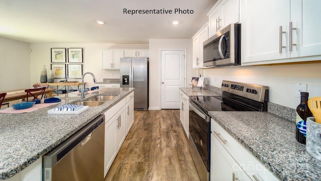 3748 13th St NE, Hickory, NC 28601 - kitchen with stainless steel appliances, a sink, dark wood-style flooring, white cabinetry, and light stone counters