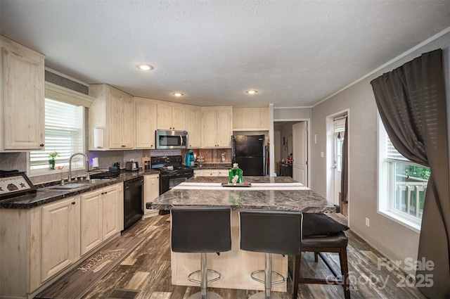 251 Birch Tree Rd, Clover, SC 29710 - kitchen featuring black appliances, a kitchen island, a kitchen breakfast bar, dark wood-style flooring, and decorative backsplash
