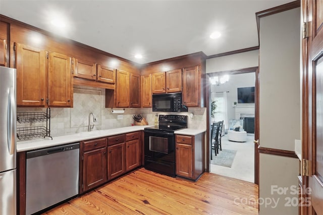 2308 Blair House Ct, Charlotte, NC 28270 - kitchen with black appliances, light countertops, backsplash, light wood-type flooring, and crown molding