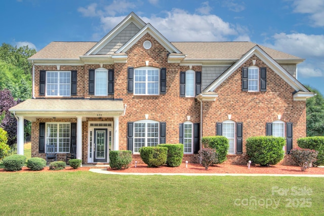 604 Palmerston Ln, Waxhaw, NC 28173 - colonial house with brick siding, a front yard, and roof with shingles