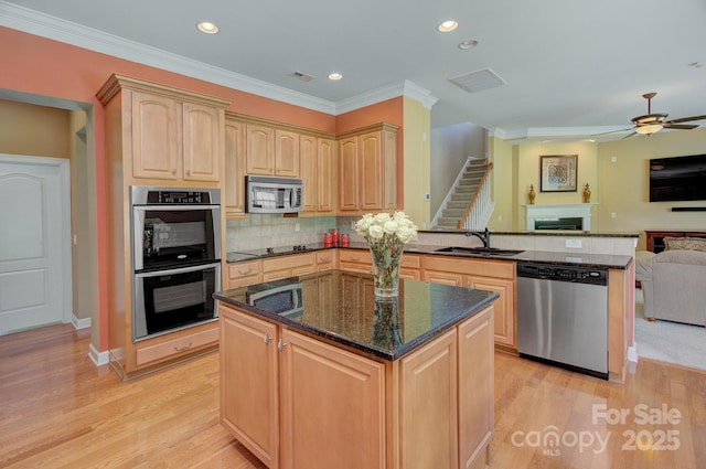 604 Palmerston Ln, Waxhaw, NC 28173 - kitchen featuring appliances with stainless steel finishes, light brown cabinets, open floor plan, a fireplace, and a peninsula