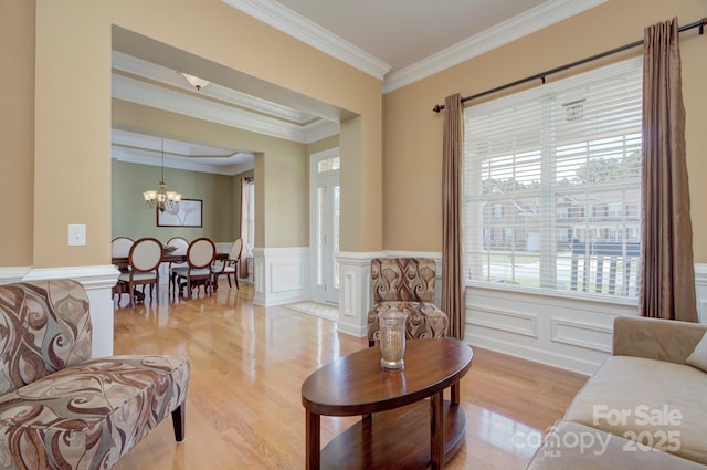 604 Palmerston Ln, Waxhaw, NC 28173 - living area with a chandelier, ornamental molding, light wood-style floors, a decorative wall, and a wainscoted wall