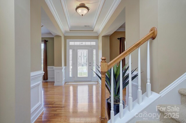 604 Palmerston Ln, Waxhaw, NC 28173 - entryway with stairs, wood finished floors, ornamental molding, a wainscoted wall, and a raised ceiling