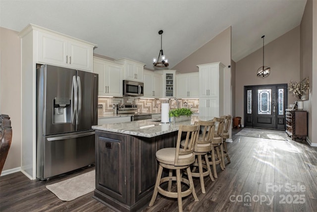 4933 NC Highway 268 W, Wilkesboro, NC 28697 - kitchen with appliances with stainless steel finishes, a chandelier, dark wood-type flooring, white cabinets, and high vaulted ceiling