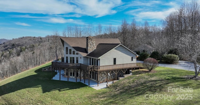 4933 NC Highway 268 W, Wilkesboro, NC 28697 - back of property with a chimney, a wooden deck, a yard, a patio, and a wooded view