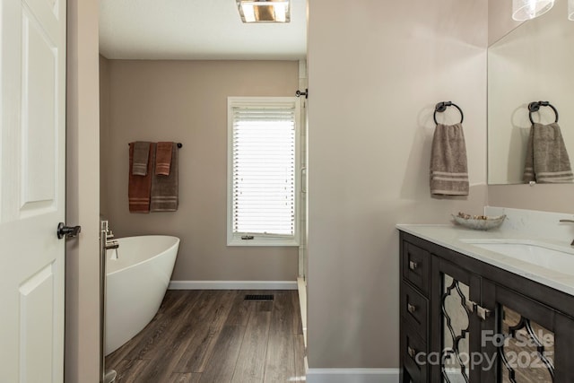 4933 NC Highway 268 W, Wilkesboro, NC 28697 - full bathroom featuring vanity, a soaking tub, wood finished floors, and baseboards